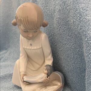 Zaphir porcelain figurine titled "Girl with Babydoll" or "Pretending”